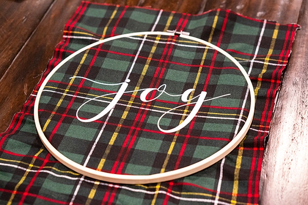 Embroidery hoop Christmas wreath. Create this easy and beautiful Christmas wreath using HTV. It's an easy Silhouette or Cricut Christmas craft. #silhouette #cricut #christmasdecor #christmasdiy