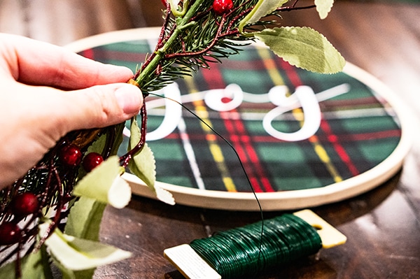 Embroidery hoop Christmas wreath. Create this easy and beautiful Christmas wreath using HTV. It's an easy Silhouette or Cricut Christmas craft. #silhouette #cricut #christmasdecor #christmasdiy