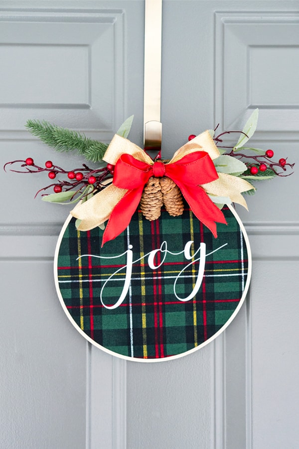 Embroidery hoop Christmas wreath. Create this easy and beautiful Christmas wreath using HTV. It's an easy Silhouette or Cricut Christmas craft. #silhouette #cricut #christmasdecor #christmasdiy