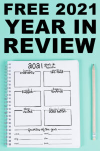 This image represents the free printable that you can download in this blog post. At the top of the image, it says Free 2021 Year in Review. Under that is a notebook on a teal blue background with a white pencil next to it. The notebook is open to the free printable available in this blog post - the free 2021 year in review printable.