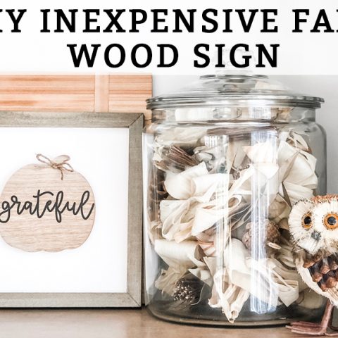 This DIY inexpensive fall wood sign is picture. It's an image of a wood sign with a light wood frame, white background, wood pumpkin, and the words grateful written in black cursive across the pumpkin. A small twine bow is on the stem of the pumpkin. The words, DIY Inexpensive Fall Wood Sign are on the top of the sign.