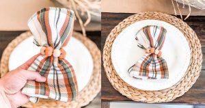 The image is of DIY Thanksgiving napkin rings. They're plaid green, orange, and white napkins with mini pumpkins and wood beads around the napkins.