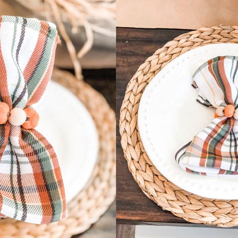 The image is of DIY Thanksgiving napkin rings. They're plaid green, orange, and white napkins with mini pumpkins and wood beads around the napkins.