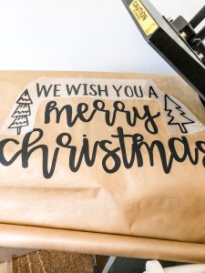 #shop This image shows kraft paper with the words, We wish you a Merry Christmas in black and two trees.
