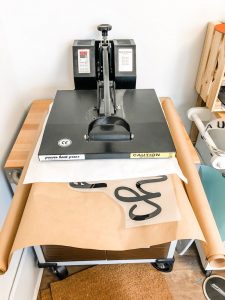 #shop This image shows a heat press pressing kraft paper with black words.