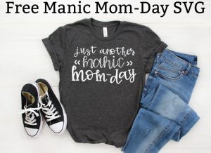 Free Manic Mom Day SVG is on the top in black text on a white background. To the bottom is an image of a gray t-shirt with the words, Just another Manic Mom-Day. Next to a pair of blue jeans and black converse sneakers.