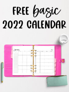 The image shows the 2022 Free Printable Calendar you can download. At the top of the image are the words Free Basic 2022 Calendar in black overlaid over light gray background. The image is of an open planner with a bright pink cover. Inside of the planner are pink tab dividers and it's open to a two page January 2022 calendar. On the top right is the lid of a white travel mug. To the bottom left next to the open planner is a mint green and gold pen. Below the planner to the bottom right is a mint green pencil pouch with a gold zipper. The pouch is zipped open.