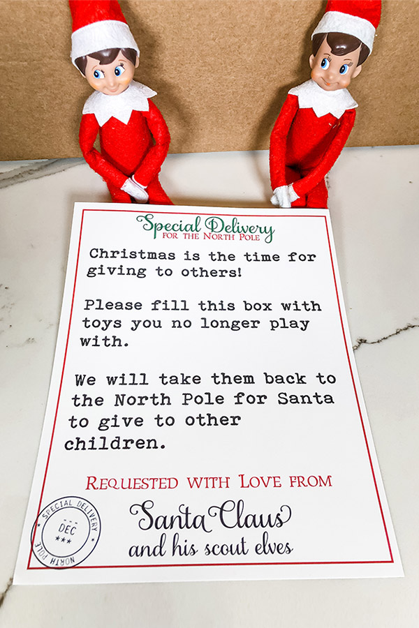 This image is for the post Elf on the Shelf Toy Donate Letter - it shows two elves on the shelf with a brown box and a copy of the free printable toy donation letter that is available to download in this blog post.