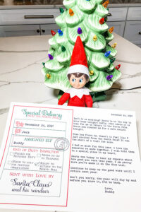 This image shows a free elf goodbye letter for the Elf on the shelf. The image shows an elf with a copy of the free customizable letter you can download for free at the end of the blog post.