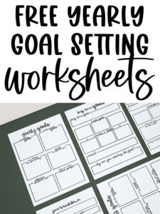 Free yearly goal-setting worksheets displayed on a table, showing multiple printable pages with boxes for long-term goals, action steps, rewards, and reflections.