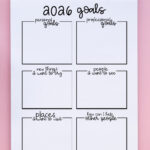 2026 goals worksheet in a spiral notebook on a pink background, showing blank boxes for personal goals, professional goals, new things to try, people to see, places to visit, and ways to help others.