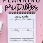 Graphic with the text “Free Goal Planning Printables” above a spiral notebook displaying a 2026 goals worksheet on a pink background with decorative stars.