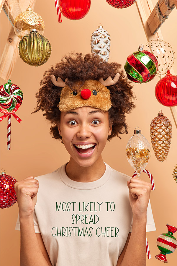 Photo of a woman with one of the t-shirt designs on her shirt as an example of what is available in the free download pack. Her shirt says, "most likely to spread Christmas cheer."