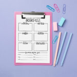 2025 year-in-review worksheet on a pink clipboard against a lavender background, styled with pastel pens, erasers, and colorful paper clips. The page includes boxes for memories, lessons, challenges, projects, and yearly favorites.