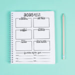 2025 year-in-review worksheet in a spiral notebook on a mint green background with a wooden pencil beside it, featuring sections for favorite moments, lessons learned, places visited, and favorites of the year.