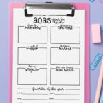 2025 year-in-review worksheet on a pink clipboard against a lavender background, surrounded by pastel pens, erasers, and paper clips. The page includes boxes for memories, lessons, bumps in the road, projects, and yearly favorites.