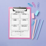 2025 year-in-review worksheet on a pink clipboard over a lavender background, styled with pastel pens, sticky erasers, and paper clips arranged around the page.