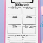 2026 year-in-review worksheet on a pink clipboard over a lavender background, styled with pastel pens, sticky erasers, and paper clips arranged around the page.
