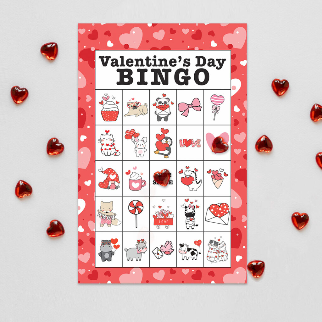 This image shows the free valentine bingo available to download at the end of this post. This image is showing one of the 40 free printable valentine bingo cards you can download. Around the card are little glass red hearts surrounding it.The valentine bingo card shown says Valentine’s Day bingo at the top. Below that, are cute little valentine symbols on a traditional bingo game board. There are 24 cute valentine pieces of clip art and one free space in the middle.