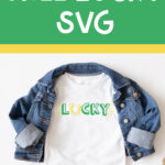 This image shows one of the free lucky SVG files you can download at the end of this blog post. This version is the print lucky with a horseshoe replacing the letter u. The horseshoe is yellow and facing up like a U. The text for the rest of lucky is in green. In this image, it is on a white shirt with a jean jacket over top. In the bottom right corner are some gold coins and some glittery paper shamrocks. Above the shirt is the text, Free Lucky SVG in white on a green background.
