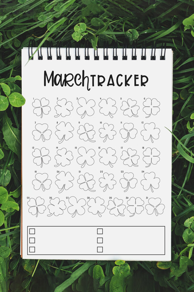 This image shows the March mood tracker available to download at the end of this post. At the top of the image, it says Free March Mood & Habit Tracker in black text overlayed on green. Below that is an image of the March mood and habit tracker on a notebook in a field of green clover.