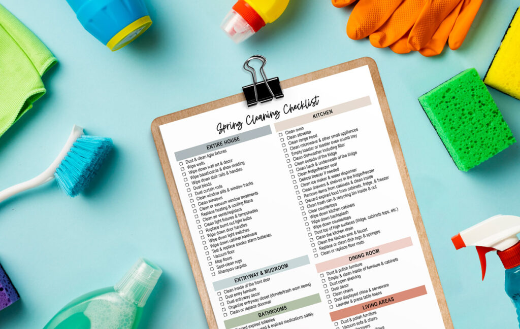 This image is showing the spring cleaning checklist you can download for free at the end of this post. It shows a copy of one of the spring cleaning check list pages you can download for free at the end of this post on a clipboard. The clipboard is surrounded by cleaning supplies.
