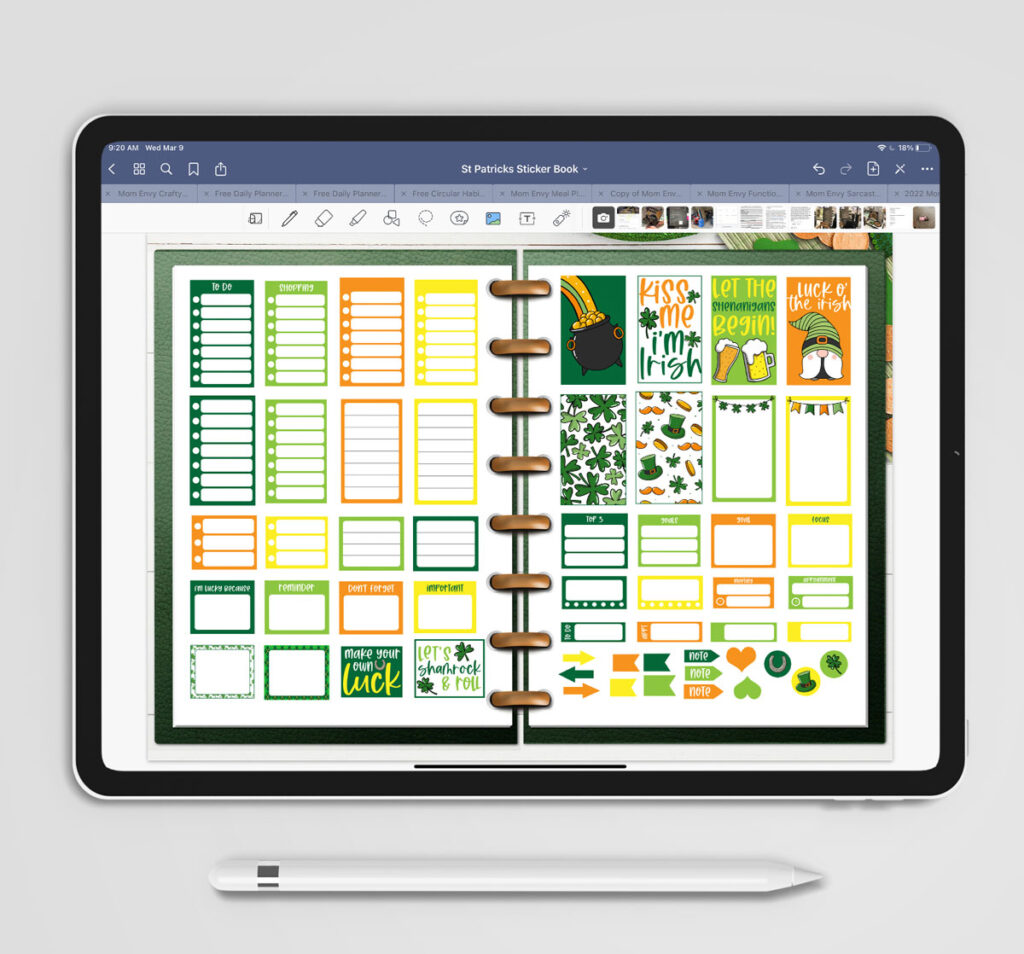 This image shows some of the available free Saint Patrick's Day stickers you can download at the end of this post. It shows an iPad and Apple Pencil. The screen is shows a Goodnotes program with an open green planner with some of the free stickers you can download. The planner is resting on some paper four leaf clovers and gold coins.