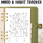 The top of the image says May Floral mood & habit tracker. Below that is a green planner with gold rings opened up to the free May Mood tracker you can download at the end of this blog post.