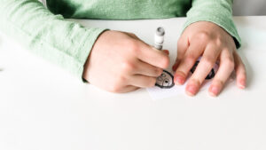 This image shows a child coloring in the free sloth head template.