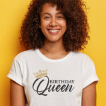 This image shows an example with one of the free svgs you can get in this blog post. It shows a girl wearing a white t-shirt with a Birthday Queen SVG. She is up against a yellow background.