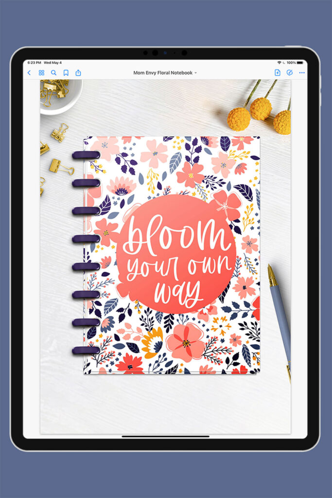 This is an image of an iPad opened up to the first page of the free Digital Notebook you can download for free at the end of this post. The notebook has a floral design with the quote, “bloom your own way” on it.