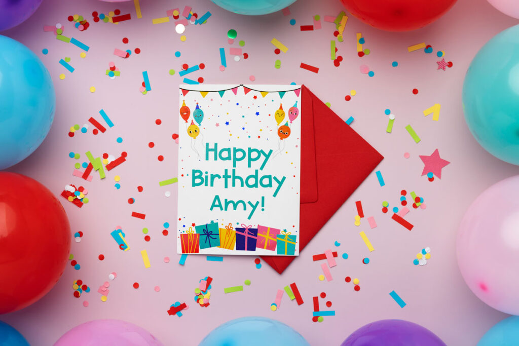 This image shows the free printable birthday card you can get at the end of this blog post. This image shows a pink background and a bunch of confetti and a red envelope. In the center, on top of the envelope, is the free birthday card printed out. It has been customized with the name Amy.