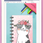 This image shows an example of what the cover looks like for the free digital cat planner. The image is of a white iPad open to a Goodnotes Digital file. The cover has a gray and white cat on it with a pink floral headband.