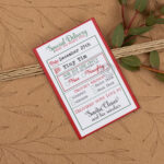 The image shows one of the tags from the Christmas tags from Santa printable set. The tag is being used like a sticker (or label) on a package wrapped with a brown wrapping paper with some brown flowers on it.