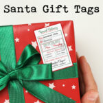 At the top the image says free printable customizable Santa gift tags. The image below that shows one of the tags from the Christmas tags from Santa printable set. The tag is on a package wrapped with red wrapping paper and a green bow.