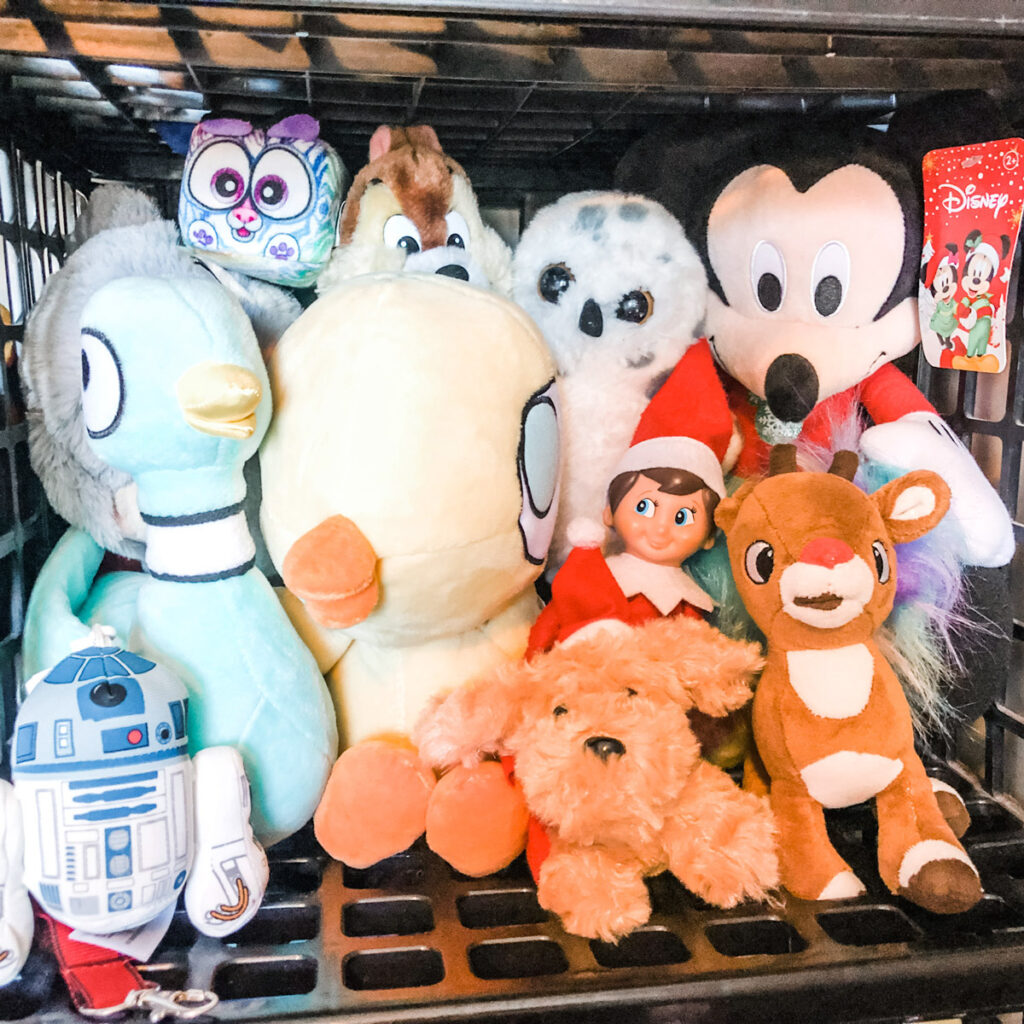 In this picture, there is an elf on the shelf doll hidden within a pile of stuffed animals. This is one of the many elf on the shelf ideas for home included in this post.