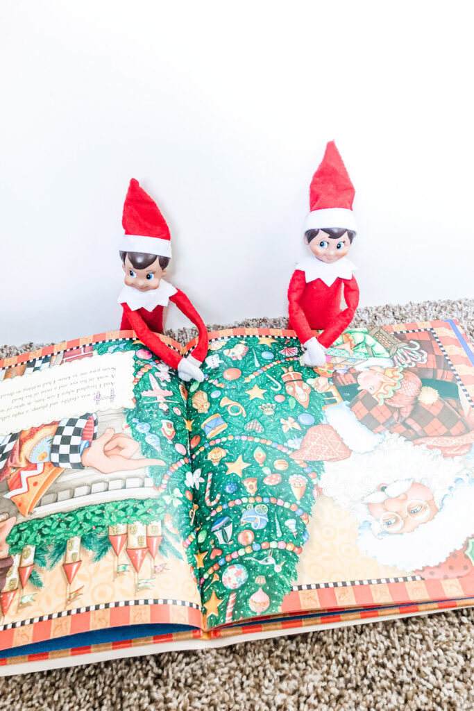 This image has 2 elf on the shelf dolls reading the Night Before Christmas. This is one of the many elf on the shelf ideas for home included in this post.