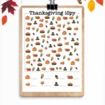 At the bottom, the image says free Thanksgiving I Spy printables. The image has leaves and pumpkins at the top. Below that is a clipboard with the colorful, harder Thanksgiving iSpy worksheet.