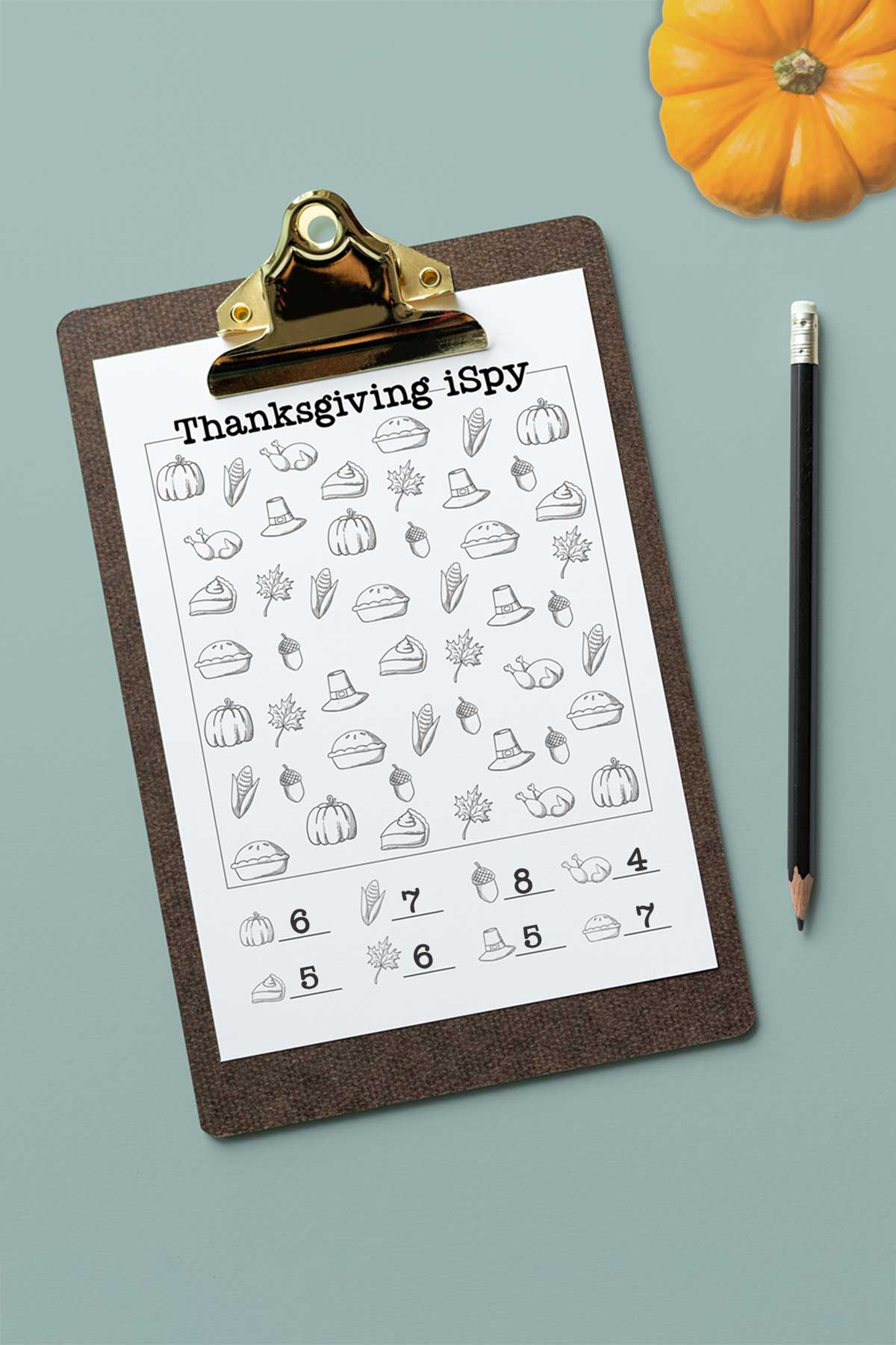 This image shows one of the answer keys for the free I Spy Thanksgiving printables you can grab for free at the end of this post. The image has a small orange pumpkin in the upper right hand corner. Below that is a clipboard with the black and white, easier Thanksgiving iSpy worksheet.