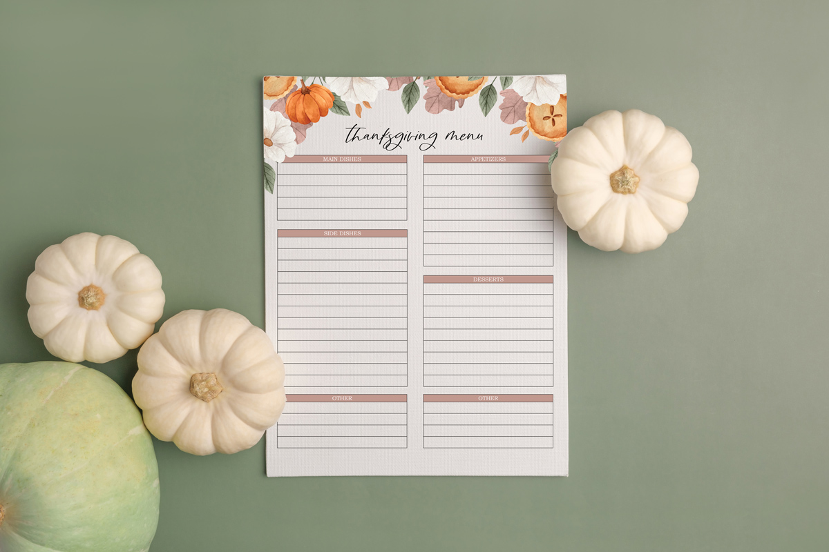 This image shows one of the free Thanksgiving menu planners you can get as part of the Thanksgiving shopping list printable, to do lists, and menu planner set at the end of this blog post. This image shows the meal planner surrounded by some pumpkins.