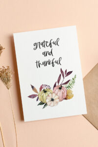 This image shows one of the free Thanksgiving cards you can get from the thanksgiving cards printable set. This card says grateful and thankful. Below that are some pumpkins and some fall foliage. It is surrounded by a few fall flowers.