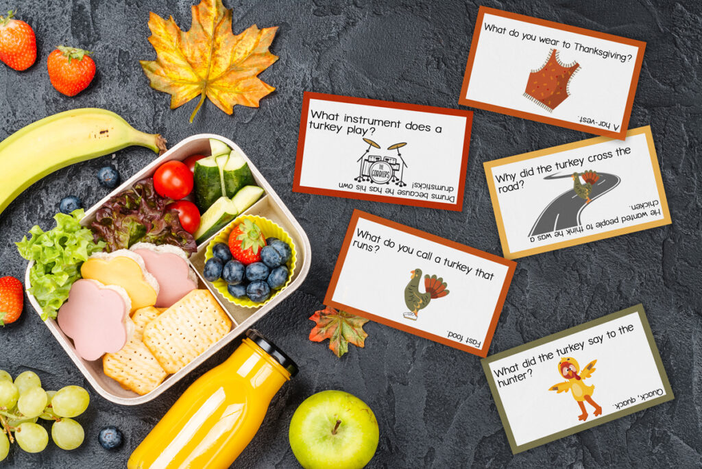 This image shows five of the 16 free Thanksgiving lunch joke notes you get for free at the end of this blog post. In addition, you get a list of a total of 45 of the best Thanksgiving jokes for kids. In the image the notes are sitting on a table next to a child’s lunchbox.