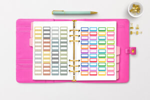 This image shows a planner open to two of the pages you can get in the free printable habit tracker stickers set.