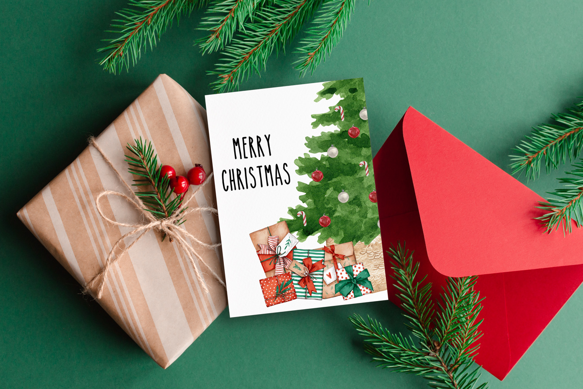 This image shows one of the designs you can get in this free Merry Christmas printable set of cards and prints. It says Merry Christmas on it and has a picture of a Christmas tree with presents underneath of it.