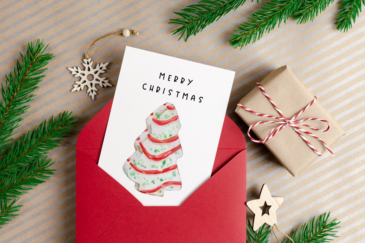 This image shows one of the designs you can get in this free Merry Christmas printable set of cards and prints. It says Merry Christmas on it and has a picture of a Little Debbie Christmas snack cake.