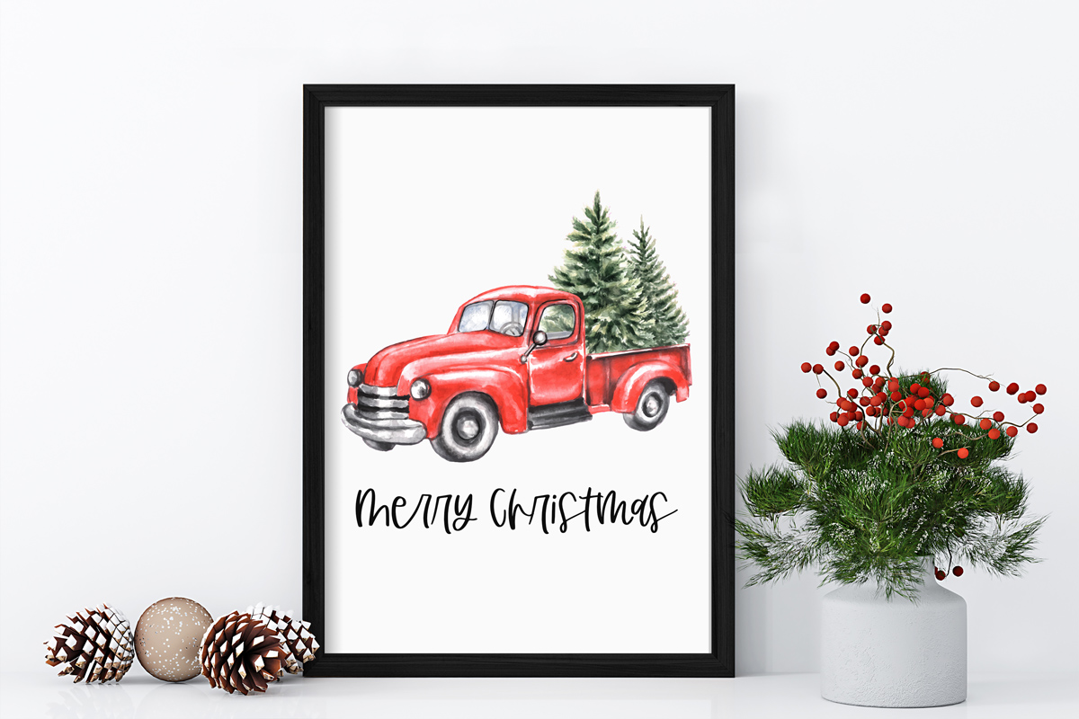 This image shows one of the designs you can get in this free Merry Christmas printable set of cards and prints. It says Merry Christmas on it and has a picture of a red Christmas truck with trees in the truck bed.