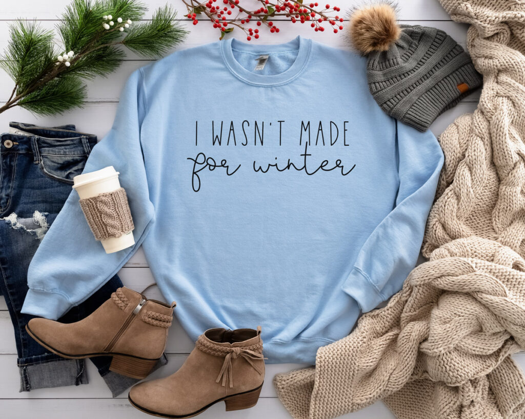 This image shows one of the free winter SVGs you can get at the end of this blog post. The SVG showing is on a sweatshirt and says, “I wasn’t Made for Winter.”