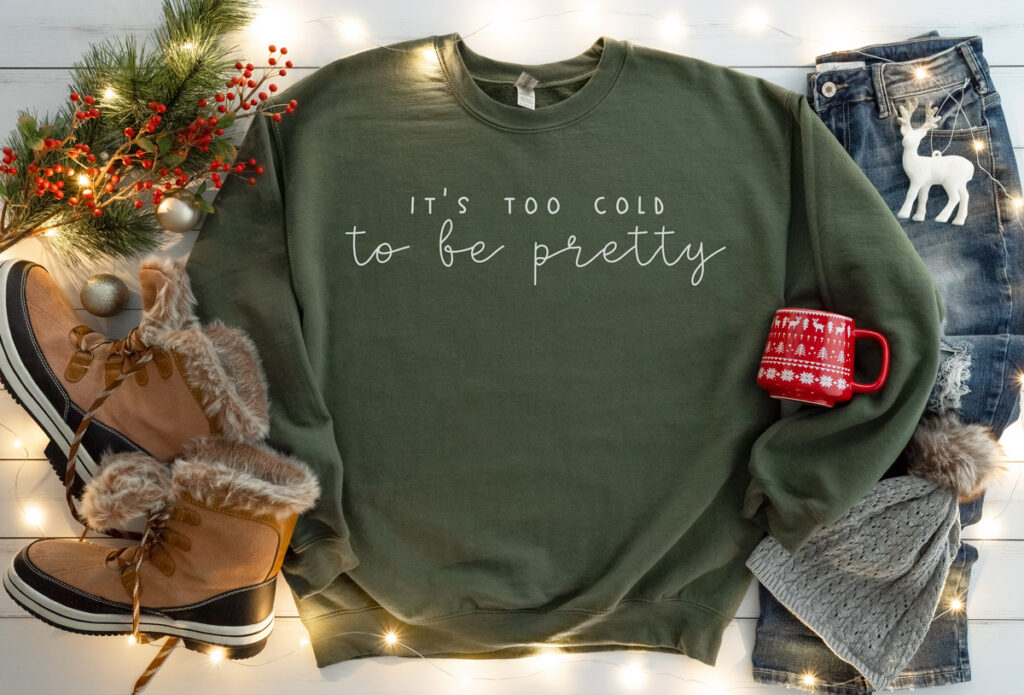 This image shows one of the free winter SVGs you can get at the end of this blog post. The SVG showing is on a sweatshirt and says, “It’s too cold to be pretty.”