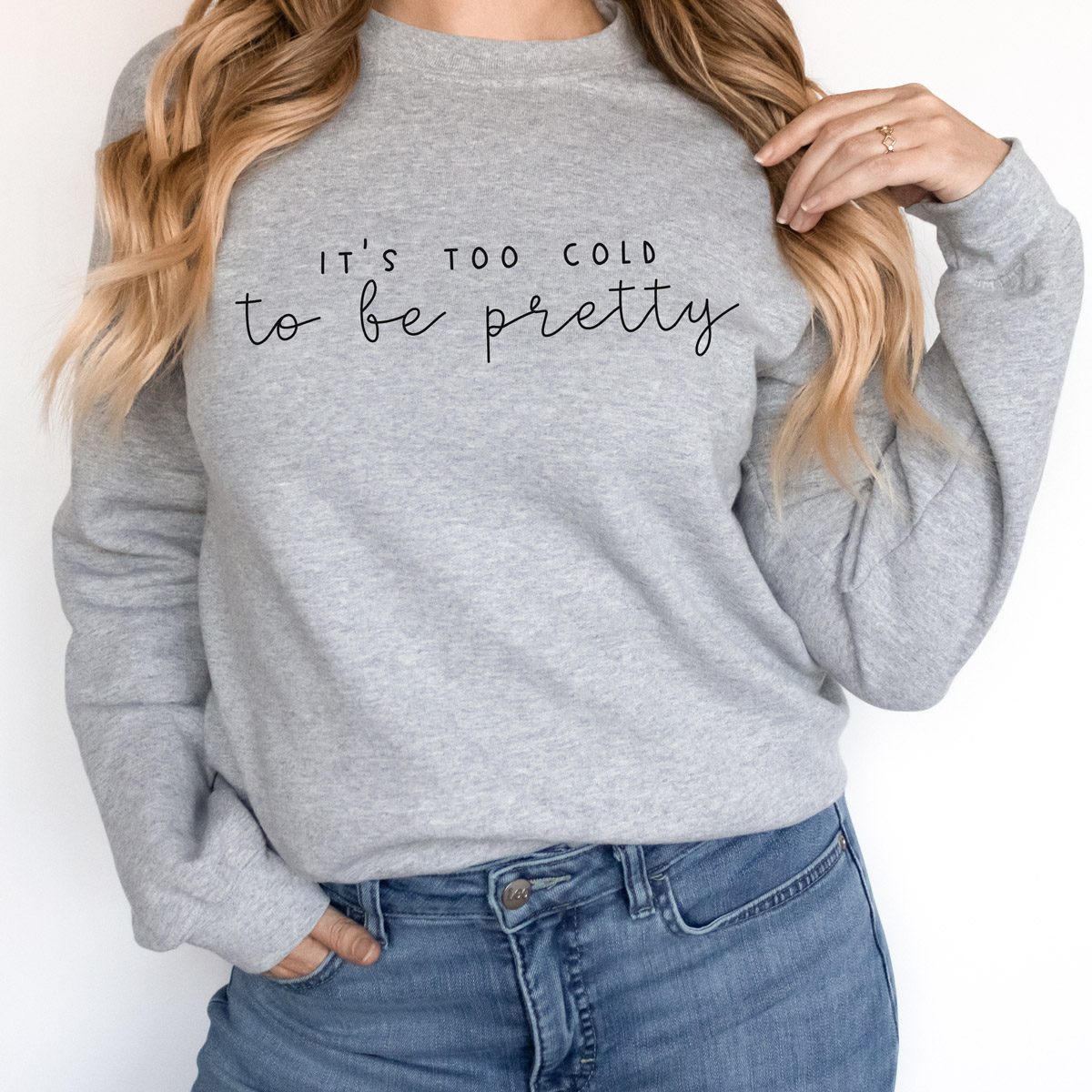 This image shows one of the free winter SVGs you can get at the end of this blog post. The SVG showing is on a sweatshirt and says, “It’s too cold to be pretty.”