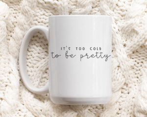 This image shows one of the free winter SVGs you can get at the end of this blog post. The SVG showing is on a mug and says, “It’s too cold to be pretty.”